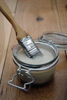 a paintbrush is sitting in a jar on the floor