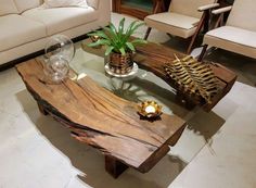 a wooden table sitting on top of a white floor next to two chairs and a couch