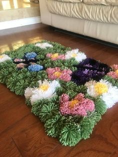 a rug with flowers on the floor in front of a couch