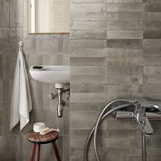 a bathroom with a sink, mirror and towel rack on the wall next to it