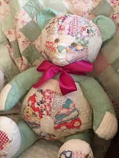 a teddy bear sitting on top of a quilt covered chair