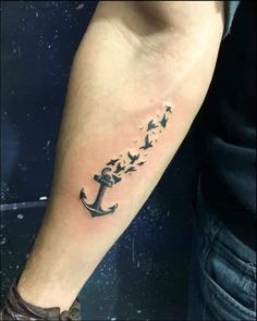 an anchor tattoo on the arm with birds flying around it and stars in the sky