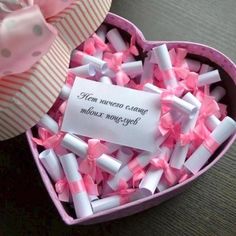 a pink heart shaped box filled with lots of small white and pink confetti