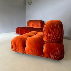 an orange couch sitting on top of a white floor