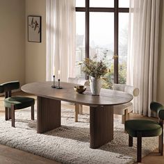 a dining room table with chairs around it and a vase filled with flowers on top