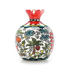 a colorful vase with a palm tree on the front and red bow at the top