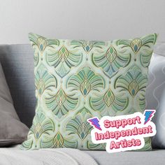 a pillow with the words support independent artists on it sitting on a couch next to pillows