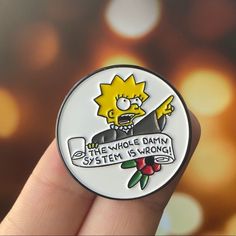 a person holding a badge with the simpsons saying, the whole damn system is wrong