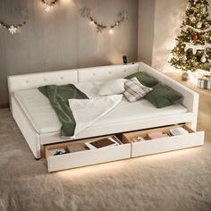 a bed with two drawers underneath it and a christmas tree in the background