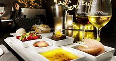 a table topped with plates of food and glasses of wine