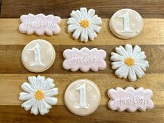 decorated cookies with white frosting and daisies are arranged on a wooden table top