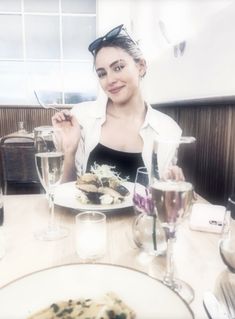 a woman sitting at a table with food in front of her