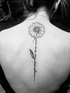 the back of a woman's neck with a flower on it