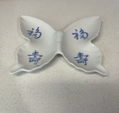 two white dishes with blue writing on them