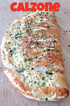 a close up of a pizza on a wooden surface with the words calzonee above it