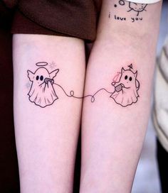 two people with matching tattoos on their arms, one has a cat and the other has a dog