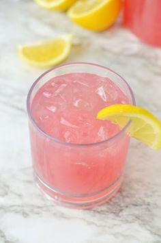 a pink drink with lemon wedges on the rim