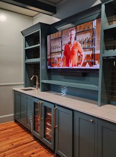 a large flat screen tv mounted to the side of a wall above a kitchen sink