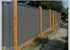 a wooden fence next to a sidewalk