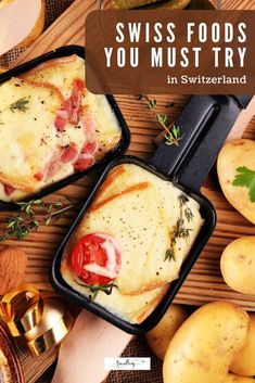 two pans filled with food sitting on top of a wooden table next to potatoes