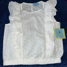 Adorable Ruffled Eyelet Sleeveless Top By Cece Brand-New With Tags In Ivory-Size Extra Small. Two Ruffles On Each Side On The Front And The Back-Elasticised Waist- One Button Closure - 100% Cotton Approximate Measurements:Iunderarm To Underarm 18”-Elastic Band Around The Bottom Across 15 Inches But Stretches-Length 19.5”-Machine, Washable, Cold (In The Description. The Only Colour Would Let Me Put Was White Or Cream, And It’s Ivory, Which Is Off White -It Doesn’t Look As White As The Pictures, B Casual Tops With Lace Trim And Ruffled Straps, Fitted Sleeveless Lace Top With Ruffles, Sleeveless Cotton Lace Top With Ruffles, Summer Sleeveless Lace Top With Ruffles, Cute Sleeveless Top With Lace Trim, Summer Tops With Lace Trim And Ruffled Straps, Cute Sleeveless Lace Trim Tops, Chic Tops With Lace Trim And Ruffled Straps, Spring Sleeveless Lace Top With Ruffles