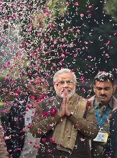 an old man standing in front of confetti falling from his mouth and hands