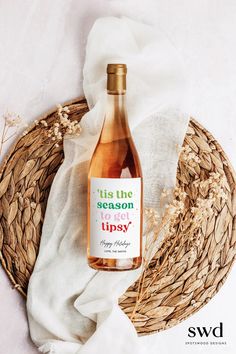 a bottle of wine sitting on top of a table next to a wicker basket