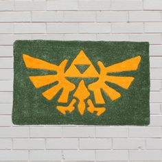 a door mat with the legend of zelda symbol on it in front of a brick wall