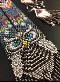 the beaded bracelet is decorated with an owl and tassels on it's side