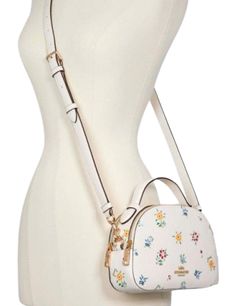 Printed coated canvas and smooth leatherInside multifunction pocketDouble zip closure, fabric liningHandle with 2" dropOutside slip pocketDetachable strap with 21" drop for shoulder or crossbody wear8 1/4" (L) x 5 3/4" (H) x 2 1/2" (W)Style No. C4252Color: Chalk Multi Wild Meadow, 4 H, Chalk, Satchel, Canvas, Fabric