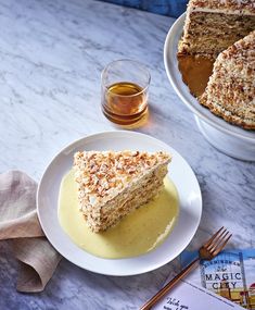 a piece of cake sitting on top of a white plate next to a cup of tea