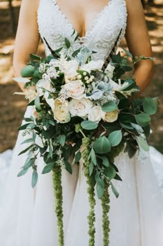 a bride holding her bouquet in the woods