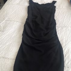 a black dress laying on top of a bed