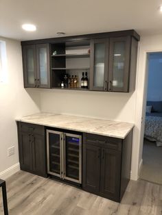 an empty kitchen with wine cooler and cabinets