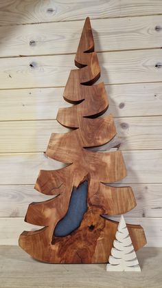 a wooden christmas tree with snow on the bottom and white pine trees in the middle