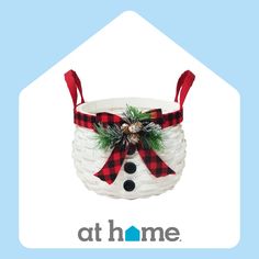 a white basket with a red and black bow on the top that has a snowman in it