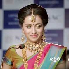 a woman in a colorful sari with jewelry on her neck