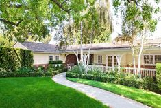 a house with trees and grass in the front yard