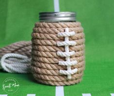 a rope wrapped mason jar with a football design on the front and white stripes around it