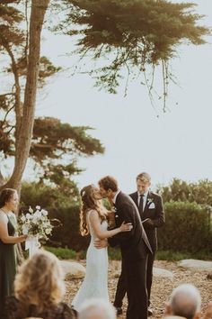 a bride and groom kissing in front of an outdoor ceremony