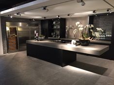 a modern kitchen with an island and wine rack on the wall in front of it