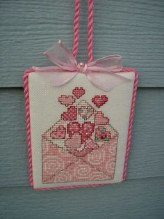 a cross stitch ornament hanging from a door