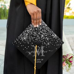 a woman holding a graduation cap with sparkles on it