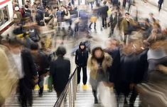 many people are walking up and down an escalator