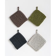 four knitted dishcloths in various colors and patterns on a white background,