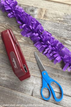 a pair of scissors and some purple tissue paper on a table next to a sharp knife