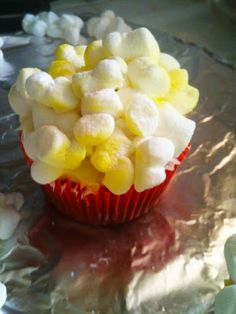 a cupcake covered in marshmallows on top of tin foil