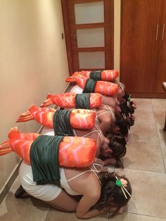 a group of women in bathing suits laying on the ground with their backs to each other