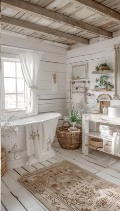 a bathroom with white walls and flooring has a rug on the floor next to the bathtub