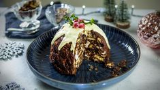 a chocolate cake on a blue plate with white icing and garnishes